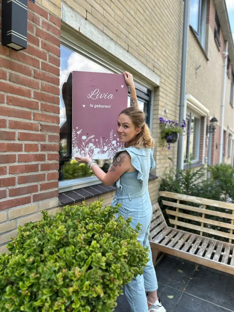 foto van Wendy eigenaar van Make it Special, op de foto is te zien dat zij een geboortebord aan het raam bevestigd